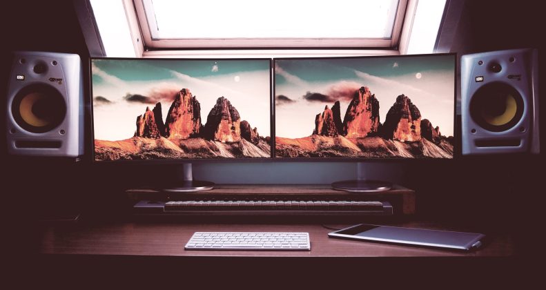 turned on two flat screen computer monitors with speakers