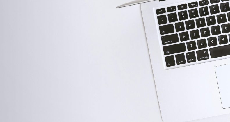 Free Aerial view of a sleek laptop keyboard on a clean, white surface, ideal for tech backgrounds. Stock Photo